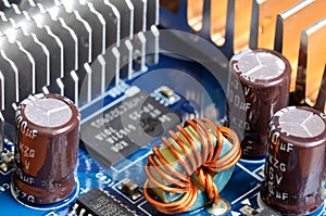 Close-up of inductors, capacitors, cooler and chips photo
