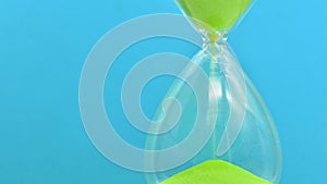 Detail of a green hourglass telling the time