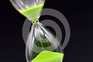 Detail of a green hourglass telling the time photo