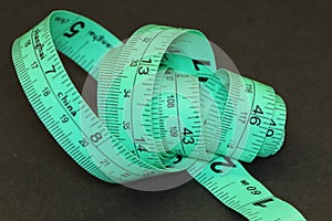 Detail of green tailor\'s tape measure in centimeters and inches