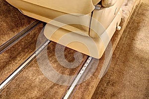 Detail of guiding rails of aircraft leather chair with brown carpet