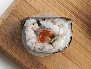 Detail of a half moon maki on a cutting board seen from above photo
