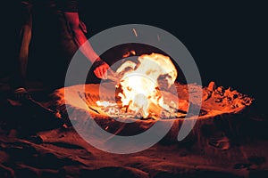 Detail of a hand making a bonfire on the beach, Long Beach, Ko Lanta, Thailand.