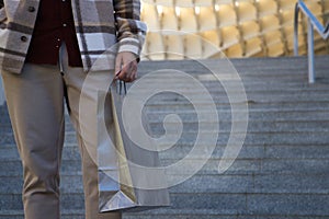 Detail hand of man holding paper shopping bag. Concept shopping and holidays