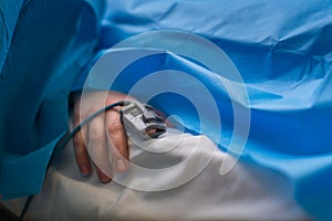 Detail of a hand of a patient being monitored dusing surgery