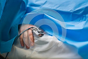 Detail of a hand of a patient being monitored dusing surgery