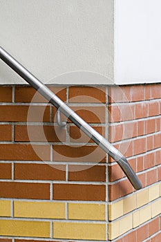 Detail of an hand rail on a brick-wall