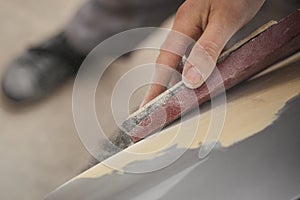 Detail of a hand sanding a vehicle photo