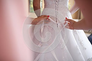 Detail of hands adjusting wedding dress lace