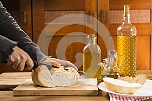 Detail of hands cutting a slice of bread