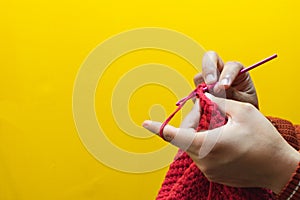 Detail of hands knitting with a crochet needle