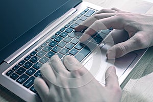 Detail of hands on laptop keyboard. Concept of technology in business and finance