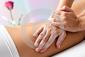 Detail of Hands massaging female hamstrings.