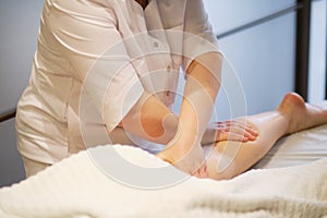 Detail of hands massaging human calf muscle.Therapist applying pressure on female leg. Hands of massage therapist