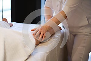 Detail of hands massaging human calf muscle.Therapist applying pressure on female leg. Hands of massage therapist