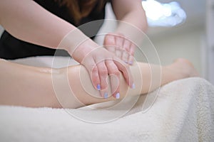 Detail of hands massaging human calf muscle.Therapist applying pressure on female leg. Hands of massage therapist