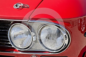 Detail of an headlight of a vintage italian red sport car