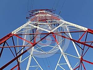 Detail of high voltage towers painted red on top of a mountain