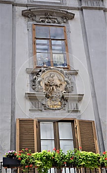 Detail of a historic building in Graz, with a window under which you can see a sculpture of the Madonna with the child in her arms
