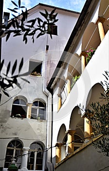 Detail of a house with arcades on the first and second floors, with flower pots, inside a courtyard in Graz.