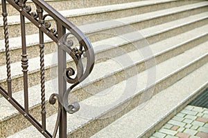 Detail of a house facade. New granite stairs with metal railings