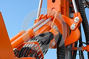 Detail of hydraulic bulldozer piston excavator arm against blue sky