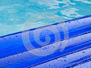 Detail of an inflatable pad floats in a swimming pool