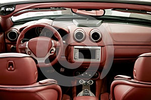 Detail of interior red sports car steering wheel speedometer