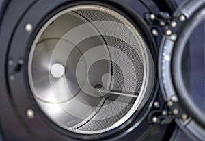 Inside view of an open and empty metal drum of a washing machine