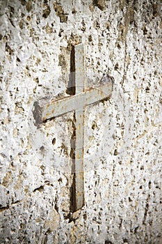 Detail of an iron cross snuggled in stone