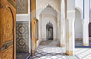 Detail of islamic building. It is an old architecture in the middle of the Moroccan city. There are white walls with wooden carved