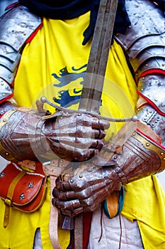 Detail knight armor. Gloves and sword of a knight.