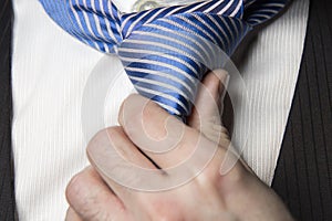 Detail of the knot at a tie over a white shirt