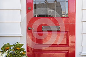 Detail of lacquered red front door to a home