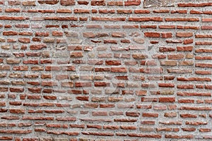 Detail of a large section of a red, brick wall worn down by time