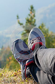 Detail of legs of a female hiker resting in grass and enjoying the view