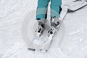 Detail of legs of young woman skier in ski boots close-up. Winter sport concept, leisure outdoor lifestyle