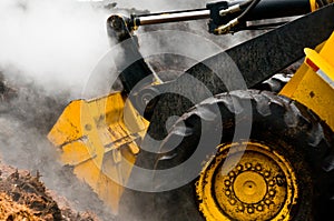 Detail loader and piles of steaming mulch