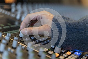 Macro shot of a hand in a control panel of a music recording studio