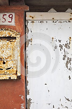 Detail of a mailbox on an orange wall with the number 59