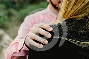 Detail of man`s hand with wounds on his wife`s shoulder, unfocused unfocused background, marriage disputes and machismo photo