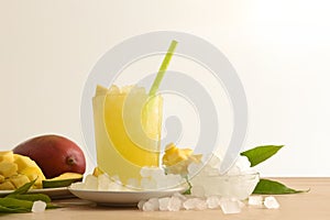Detail of mango drink with ice on table isolated background