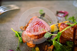 Detail of a medium roasted tuna steak served with microgreens