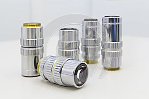 Detail of microscope lens on an white background.Closeup of microscope objectives.