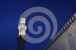 Detail of minaret of Suleymaniye mosque in Istanbul (Turkey) at night with dark blue sky in the background