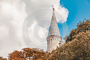 Closeup photo of the minaret of Suleymaniye Mosque | Suleymaniye Camii in front of cloudy blue sky photo