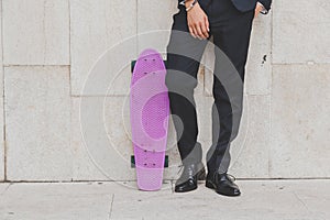 Detail of a model posing with his skateboard