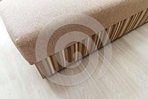 Detail of a modern beige textured sofa in living room on wooden