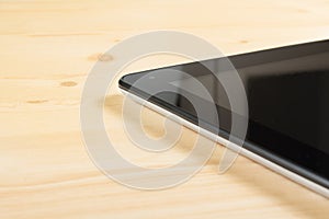 Detail of modern black tablet pc on wood table