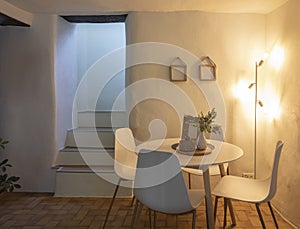 Detail of modern living room of a mountain house with a table, four designer chairs